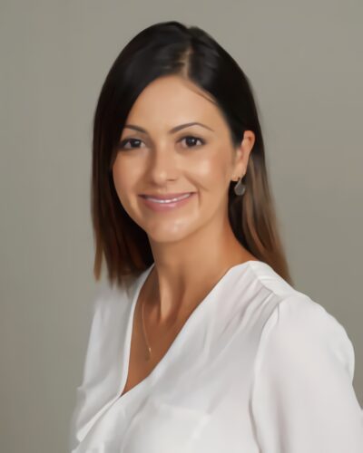 A woman in white shirt smiling for the camera.